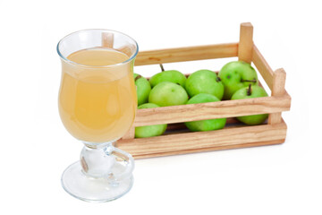 Hot apple drink in the glass mug with basket of apple fruits isolated on a white background.
