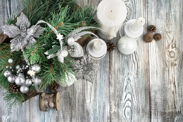 Candles with decorated pine branches on a gray wooden background. The view from the top. The concept of Christmas and the New year.