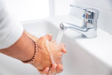 Una persona se lava las manos en el baño al llegar a casa