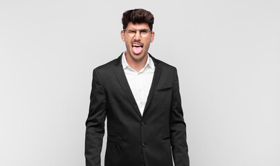 young handsome man with cheerful, carefree, rebellious attitude, joking and sticking tongue out,...