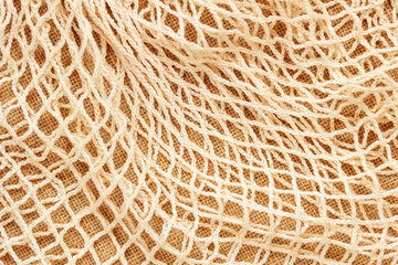 Texture of mesh string reusable knitted bag. Concept of zero waste, recycling, ecology.