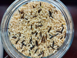 Top view of wild and brown rice mixture in glass jar. 
