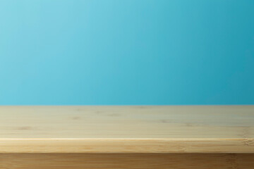 Empty wooden table with blue background. Light background with a table for objects and labels.