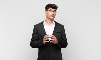 young handsome man scheming and conspiring, thinking devious tricks and cheats, cunning and...