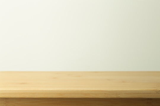 Empty wooden table with white background. Light background with a table for objects and labels.