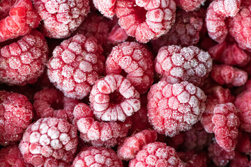 Berries of frozen raspberry in selective focus as background. Top flat lay view.