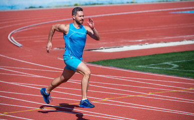 Fototapeta premium Dynamic movement of male runner on running track, run