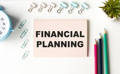 Financial Planning text on open diary with calculator, compass and sun glass.