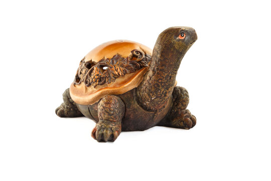 Wooden turtle figurine isolated on white background. Figurine of a turtle carved from wood.