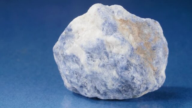 Mineral will be salted on a blue background. Decorative and ornamental stone. A nugget of close-up vision.