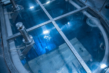 Blue glow water of nuclear reactor core powered, caused by Cherenkov radiation, fuel plates...