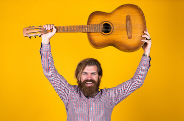 mature hipster musician with beard. brutal caucasian guy playing guitar. country music. bearded man...