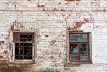 Fototapeta na wymiar Abandoned or neglected house with damaged dirty brick walls and broken window glass. Weathered dwelling in countryside or poor country. Messy exterior of deserted old building in village or city