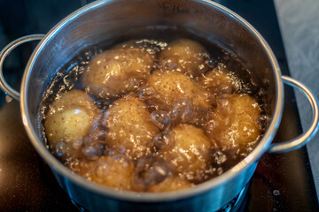 cooking potatoes in boiling water in a stainless steel pot on the stove