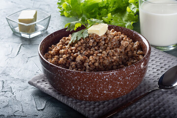 Boiled buckwheat with butter. Ready-made buckwheat in a deep dish on the table.