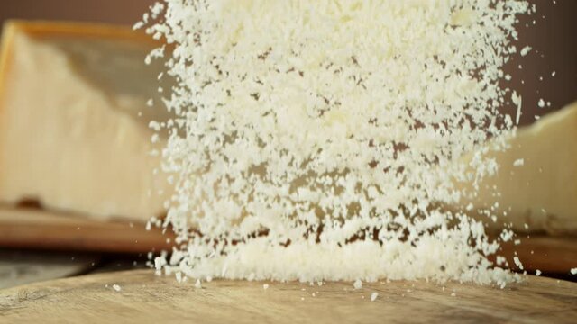 Super Slow Motion Shot of Grated Parmesan Falling on Wooden Board at 1000 fps.