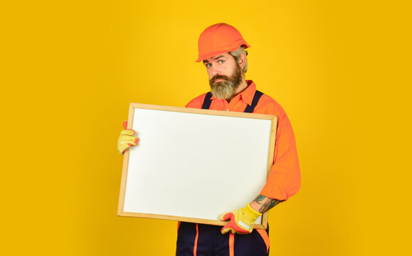 man in hard hat. Builder points to flipchart. Architect worker hold flip chart. presenting flip-chart at meeting. male construction worker. copy space. planning new project. serious man presentation