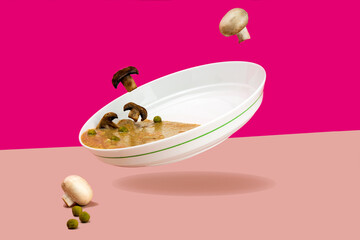 Levitating food Flying mushrooms. Mushroom cream soup champignons in a white plate On a bright pink background of fuchsia green peas. copy space