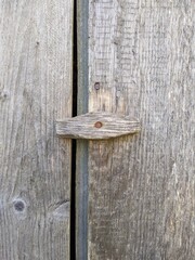 wooden and rotate gate latch on the old shabby fence