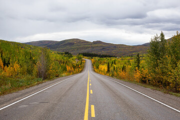 View of Scenic Road surrounded by Mountains and Trees on a Fall Day in Canadian Nature. Klondike Highway, Yukon, Canada.