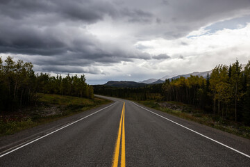 View of Scenic Road surrounded by Mountains and Trees on a Fall Day in Canadian Nature. Klondike Highway, Yukon, Canada.