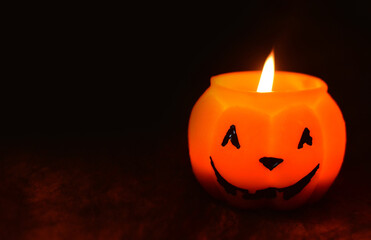 Halloween pumpkin candle against the background of a black spider web.Copy space for text