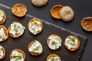 rye crispbread with cream cheese on black background