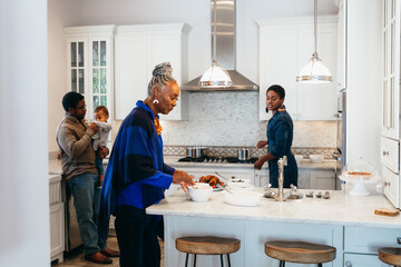 Multigenerational black family in kitchen cooking meal