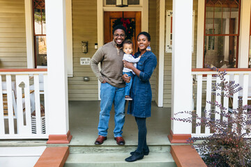 Potrait of black family and child in front of home for the holidays