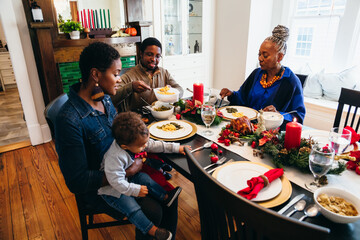 Black multigenerational family eating Kwanzaa holiday meal