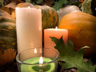 Close up burning candles with orange pumpkins. Autumn Thanksgiving background