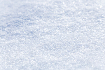 Obraz premium Close up macro photography texture of sparkling fresh white snow with light blue sky reflection tone. Selective focus. Winter christmas background.