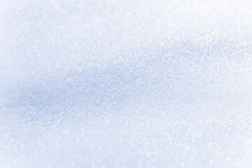Close up macro photography texture of sparkling fresh white snow with light blue sky reflection tone. Selective focus. Winter christmas background.