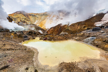 Lake in crater of active volcano. Beautiful dramatic volcanic landscape: hot spring, fumarole,...