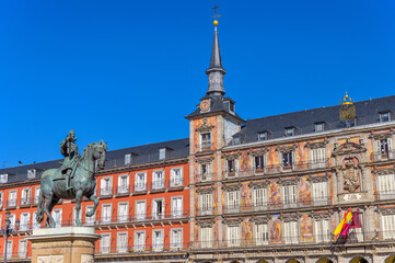 Plaza Mayor - A sunny autumn day view of the bronze equestrian statue of Philip III standing at front of one of surrounding buildings of Plaza Mayor. Madrid, Spain.