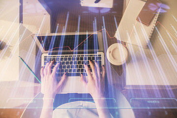 Double exposure of woman hands working on computer and forex chart hologram drawing. Top View....