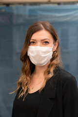 Blonde woman wearing a protective mask on the street.