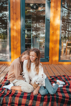 Happy kids sitting on the terrace of their house in autumn