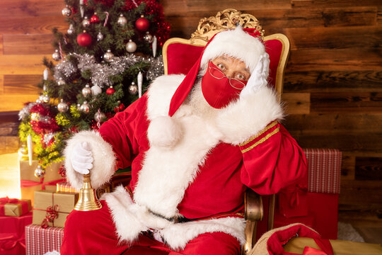 Santa Claus Sitting Near Christmas Tree with face mask.