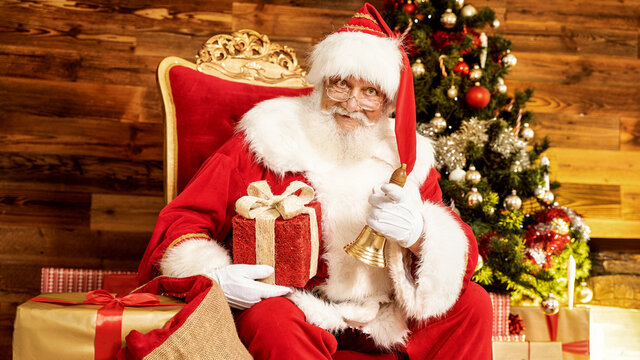 Real Santa Claus Sitting Near Christmas Tree with gifts.