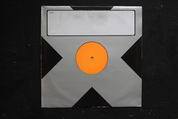 Aged black paper cover and vinyl LP record isolated on black background