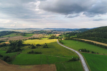 Hills and mountains among meadows. The meadows crossed by lines of trees constitute the landscape of the vicinity of Kamienna Góra in Poland © Ungrim