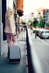 Business woman with suitcase entering hotel