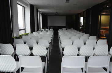 Empty conference hall with video projector and screen