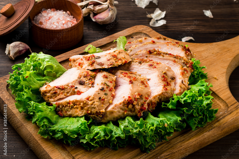 Wall mural sous vide chicken fillet on green lettuce leaves