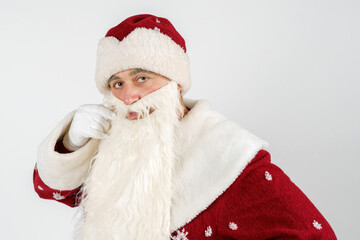 Santa Claus straightens his mustache with his hand. Isolated on white