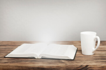 Opened bible book quran on the table. The light comes from the book.