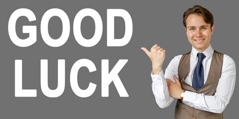 Emotional portrait of businessman showing right hand gesture on text - GOOD LUCK. Gray background.