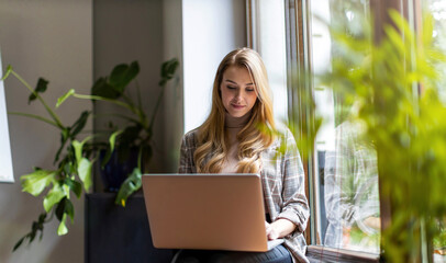 Shot of a young businesswoman with laptop in her office
