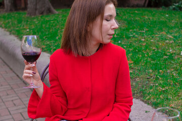 Girl in a red coat with a glass of red wine
